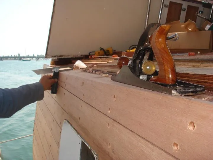 A person is using a plane on a piece of wood