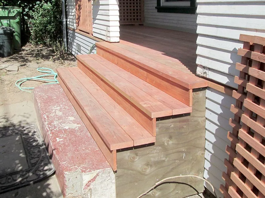 A wooden staircase is being built on the side of a house