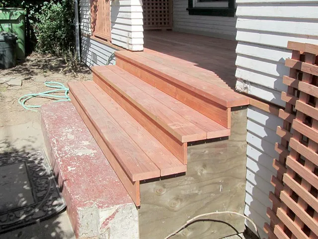 A wooden staircase is being built on the side of a house