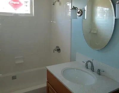 A bathroom with a sink , tub and mirror