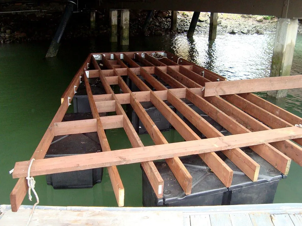 A wooden deck is being built in the water under a bridge
