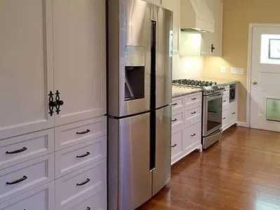 A kitchen with stainless steel appliances and white cabinets