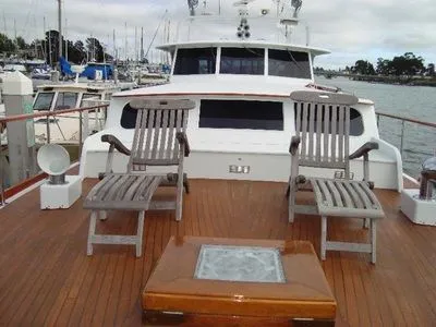 A boat with two chairs and a table on the deck