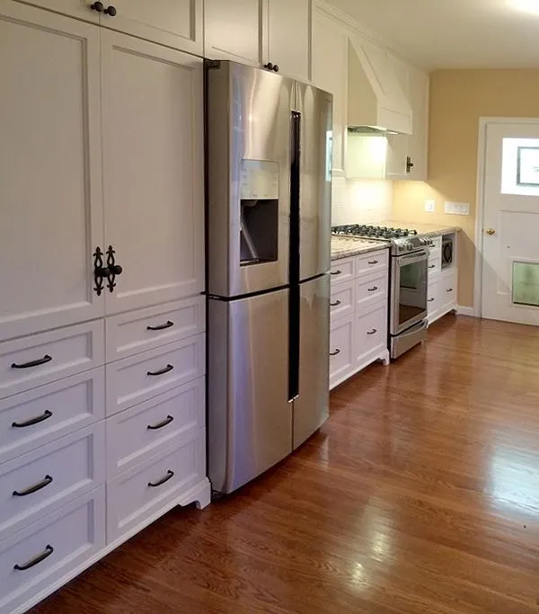 A kitchen with stainless steel appliances and white cabinets