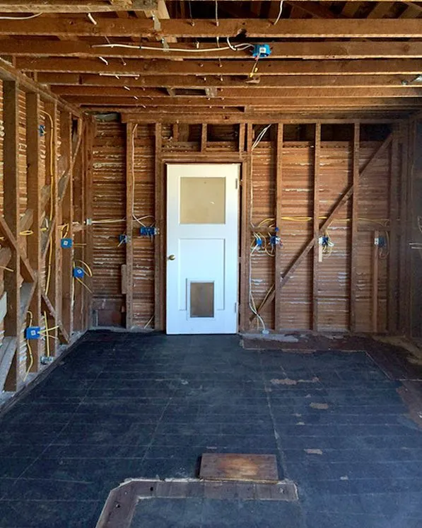 An empty room with a white door and a window