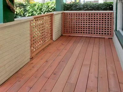 A wooden deck with a lattice fence around it