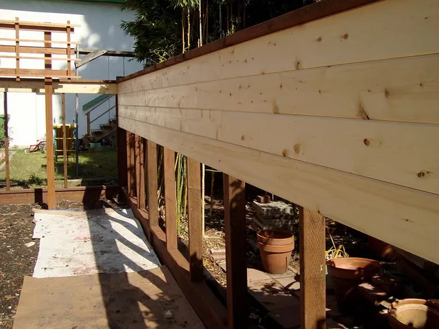 A wooden fence is being built in a backyard