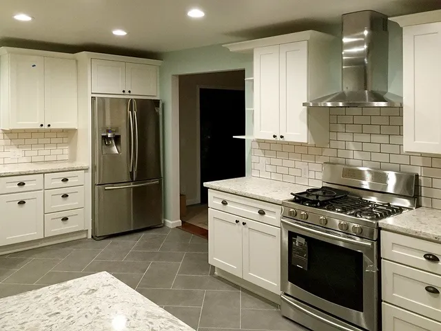 A kitchen with stainless steel appliances and white cabinets