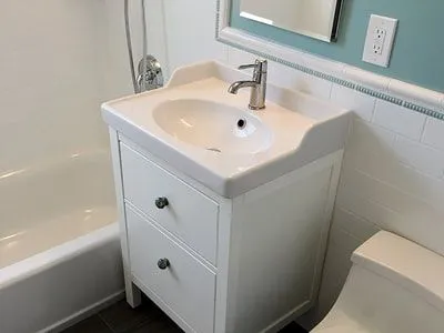 A bathroom with a sink , toilet , bathtub and mirror.