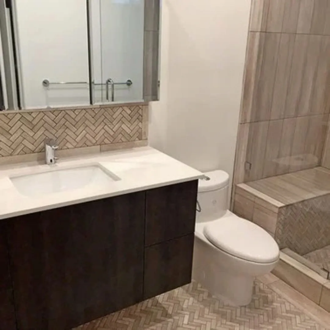 Bathroom remodel in Richmond CA with dark wood vanity, quartz countertop, and water-conserving toilet