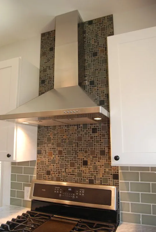 A kitchen with a stove and a hood above it