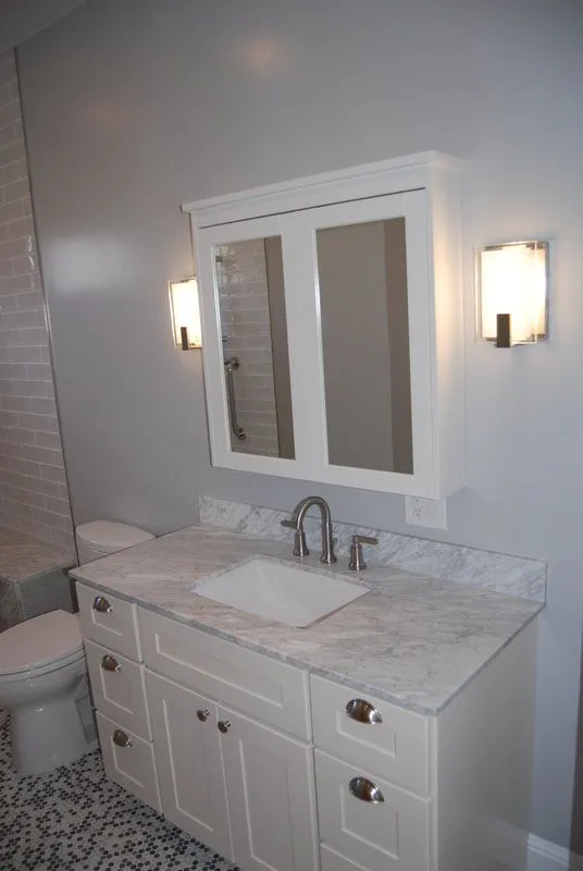 A bathroom with a sink , toilet and mirror.