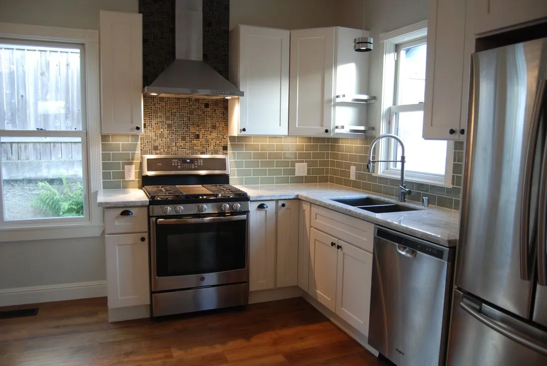 A kitchen with stainless steel appliances and white cabinets