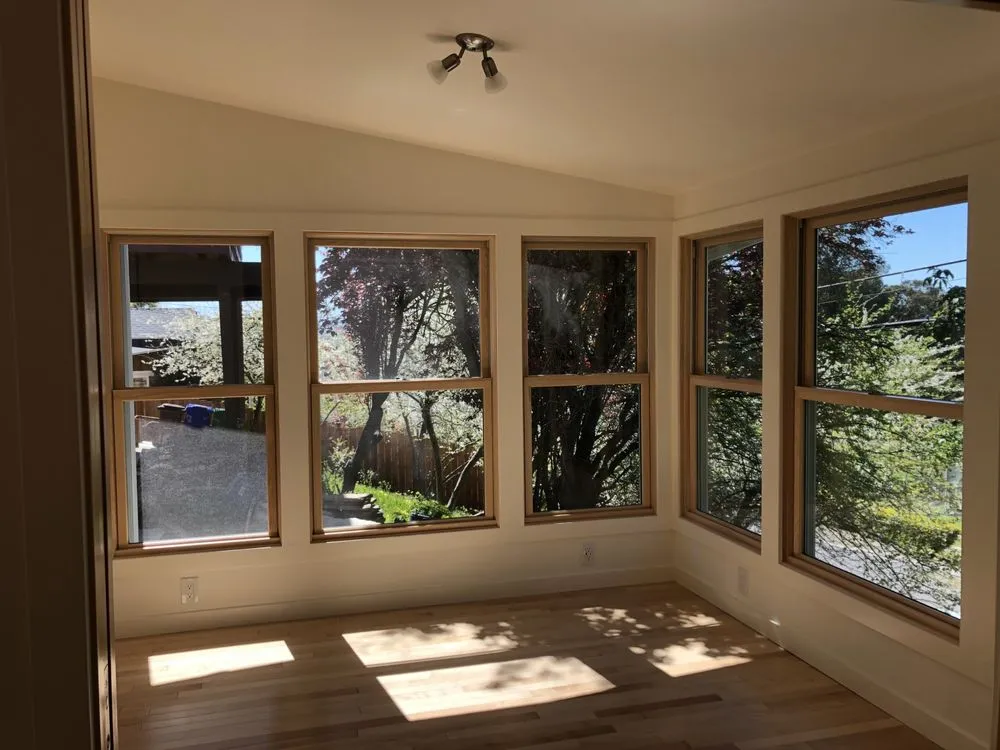 Finished home addition in Richmond, CA with vaulted ceiling, wood-trimmed windows, and hardwood floor Finished home addition in Richmond, CA with vaulted ceiling, wood-trimmed windows, and hardwood floor