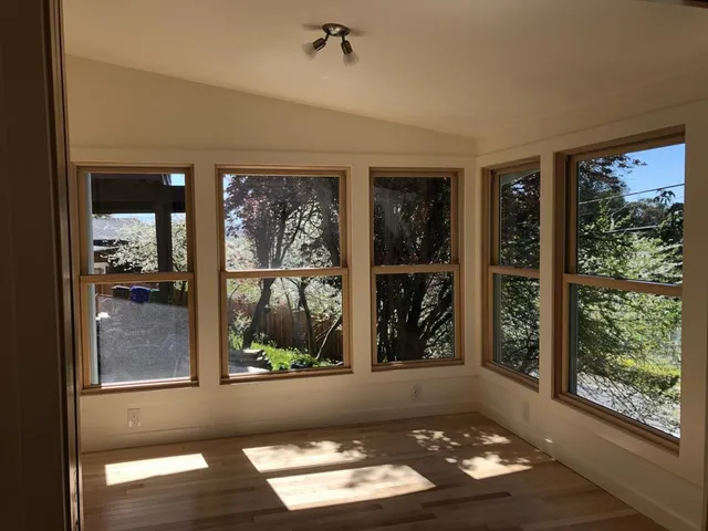 Finished home addition in Richmond, CA with vaulted ceiling, wood-trimmed windows, and hardwood floor Finished home addition in Richmond, CA with vaulted ceiling, wood-trimmed windows, and hardwood floor