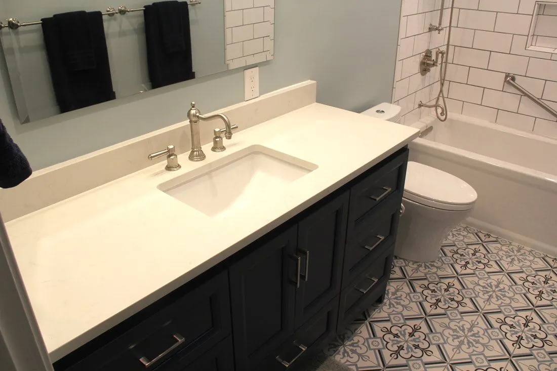 A bathroom with a sink , toilet , tub and mirror.