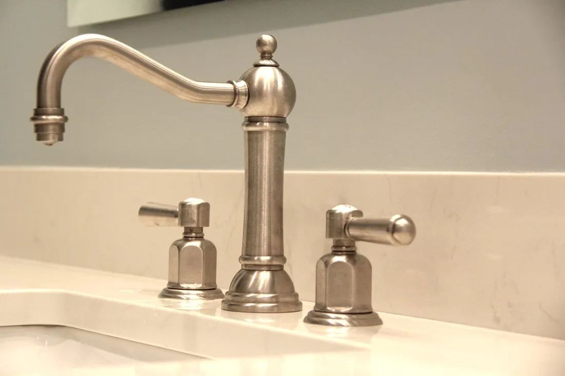 A bathroom sink with a stainless steel faucet
