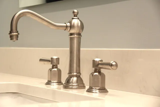 A bathroom sink with a stainless steel faucet