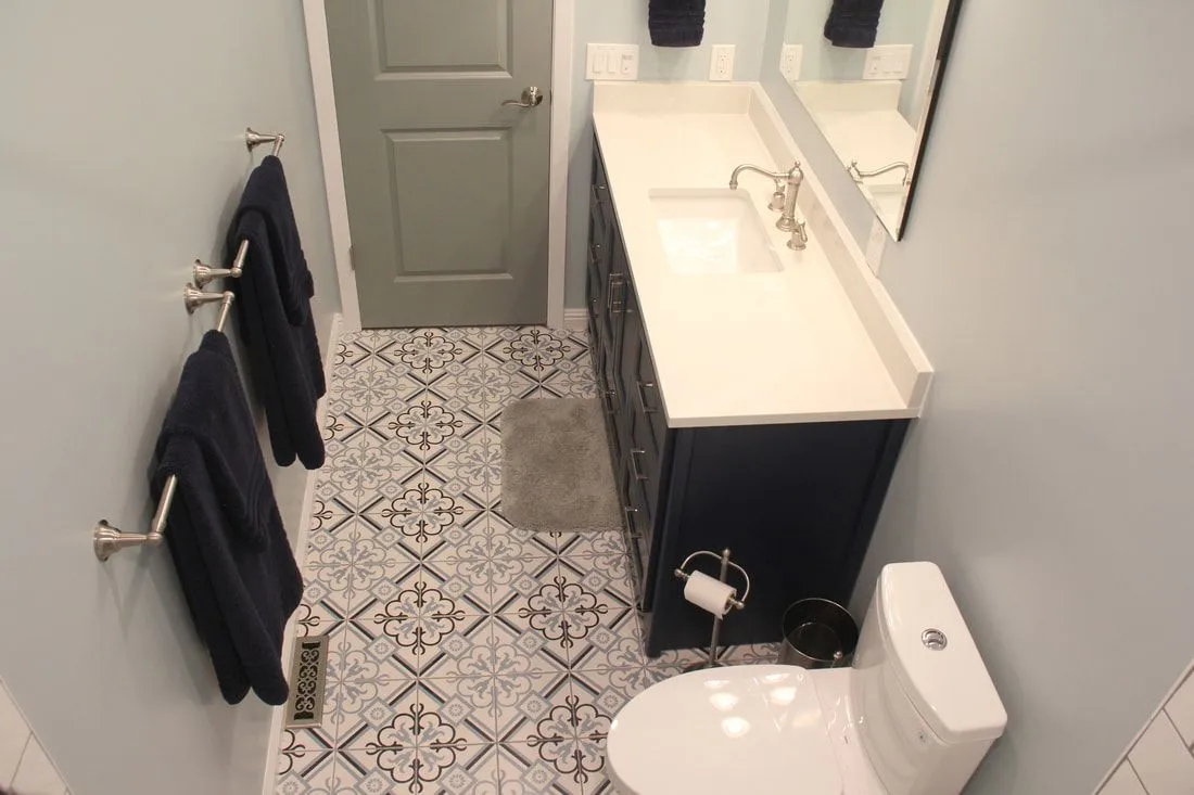 A bathroom with a toilet , sink and mirror.