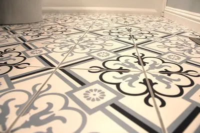 A black and white tile floor with a floral pattern.